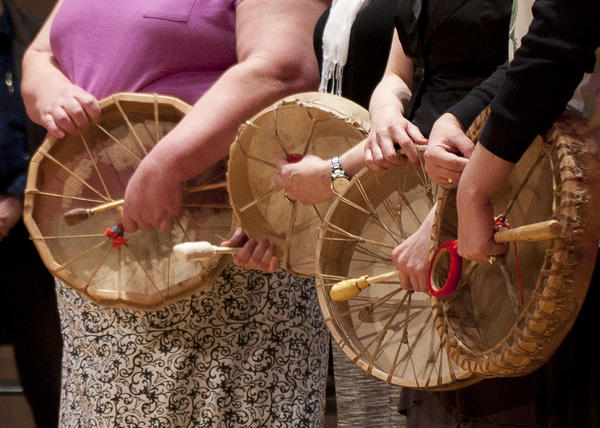 three womens hands as they play native hand drums
